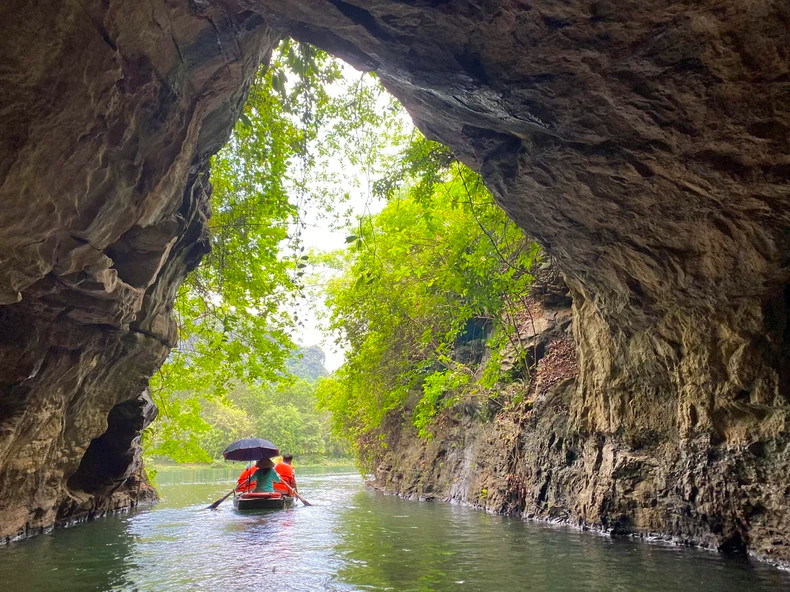Sitting on a boat to admire the enchanting beauty of Trang An's caves, is an experience favoured by tourists. (Photo: BAO NGOC)