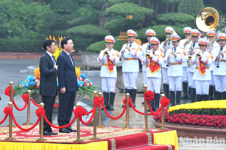 The two Presidents listen to the national anthems of the two countries.