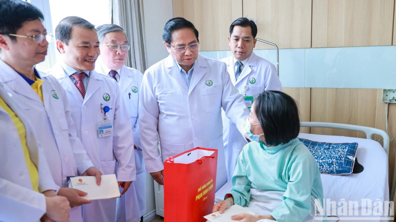 Prime Minister Pham Minh Chinh visits a patient who who has had organ transplant.