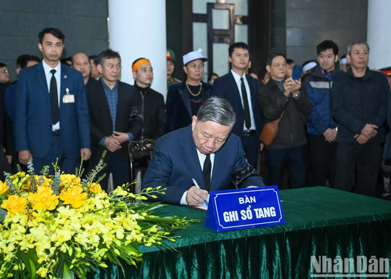 Party leader To Lam writes in the condolence book at the memorial service. Party leader To Lam writes in the condolence book at the memorial service.