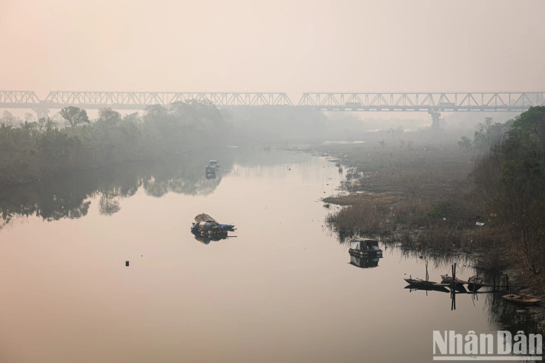 Looking towards Chuong Duong Bridge, we can see the tranquil scene of the bridge along with boats casting reflections on the Red River, creating a peaceful and poetic atmosphere. Looking towards Chuong Duong Bridge, we can see the tranquil scene of the bridge along with boats casting reflections on the Red River, creating a peaceful and poetic atmosphere.