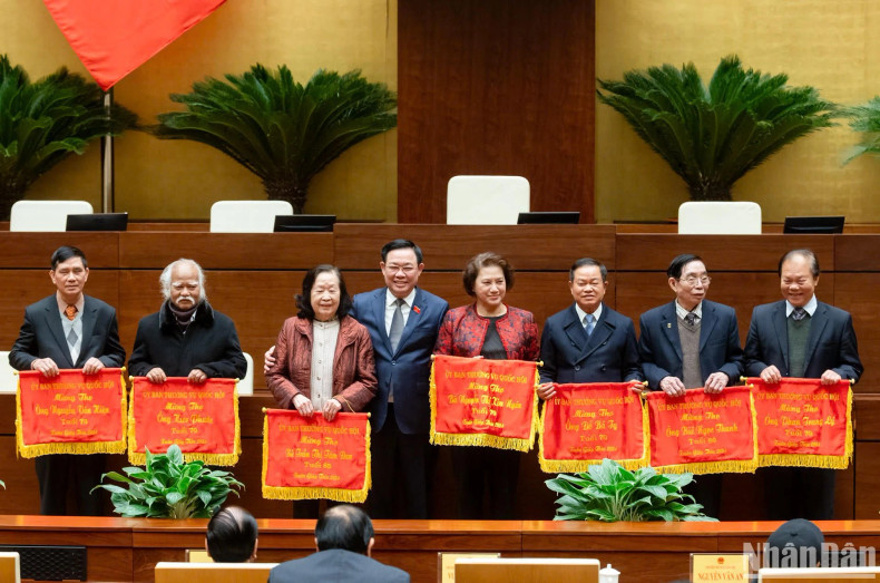 NA Chairman Vuong Dinh Hue (fourth, left) presents longevity greeting flags to over-70-year-old former NA leaders, officials and deputies. (Photo: NDO)