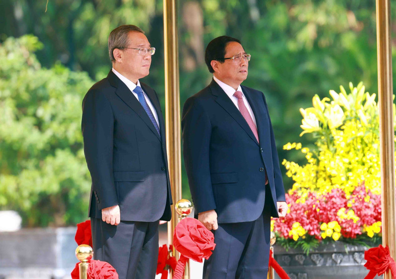 Prime Minister Pham Minh Chinh and Chinese Premier Li Qiang stand on the platform of honour as the military band plays the national anthems of both countries. (Photo: VNA)
