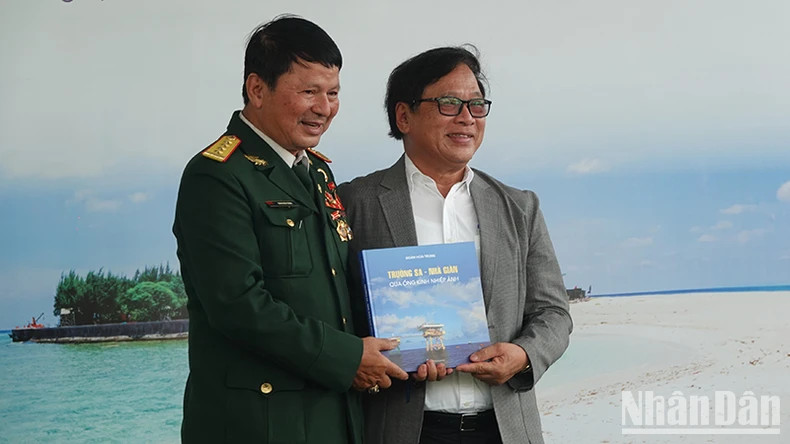 Chairman of the Ho Chi Minh City Photography Association, Doan Hai Trung, presents a photo book, titled "Truong Sa - DK Rigs" to Thu Duc City Book Street.