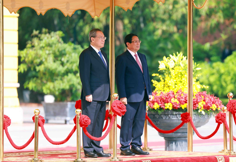 Prime Minister Pham Minh Chinh and Chinese Premier Li Qiang stand on the platform of honour as the military band plays the national anthems of both countries. (Photo: VNA)