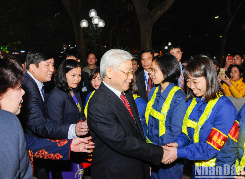 Party General Secretary Nguyen Phu Trong visits and chats with workers of the Hanoi Green Park Company who are working on New Year's Eve.