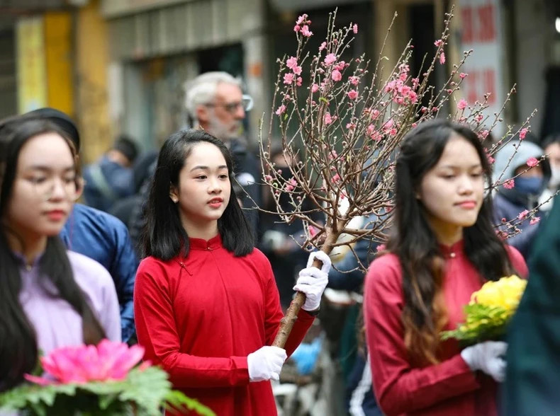 A girl carrying a peach blossom branch in the procession of offerings to the God. A girl carrying a peach blossom branch in the procession of offerings to the God.