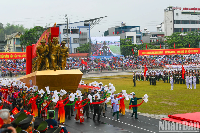 A float carrying sculptures of soldiers dragging artillery with the text “Determined to fight, determined to win”.