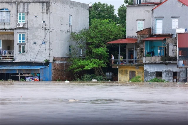 Houses in Van Ha commune are submerged by floodwaters as the river continues to overflow (Photo: VNA)