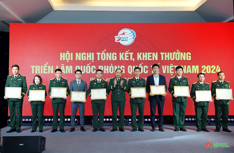 Senior Lieutenant General Phung Si Tan presents the Certificates of Merit from Chief of the General Staff of the Vietnam People's Army's to the collectives that achieved outstanding results at the expo.