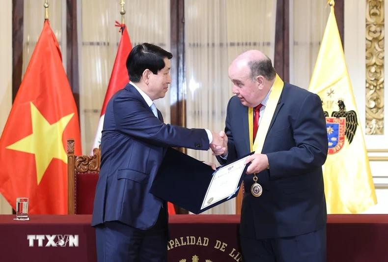 Lima Mayor Rafael Lopez awards the honorary guest certificate of Lima to President Luong Cuong.