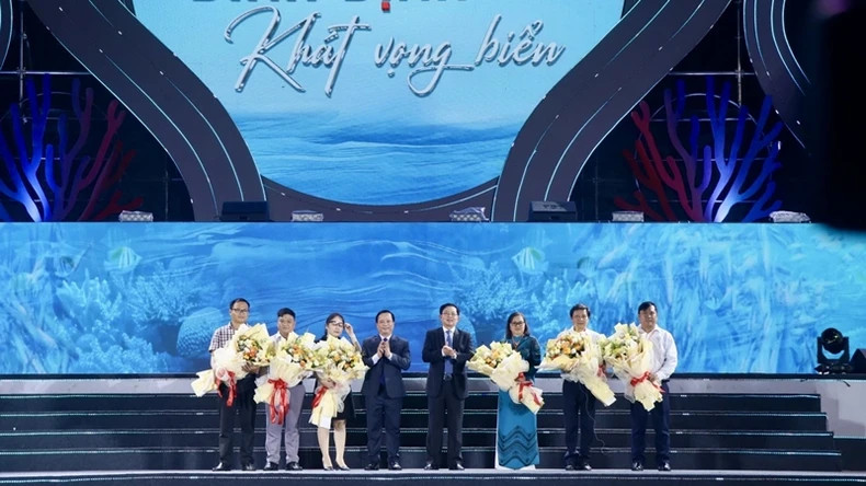 Leaders of the Binh Dinh Provincial People's Committee present flowers to representatives of sponsors.