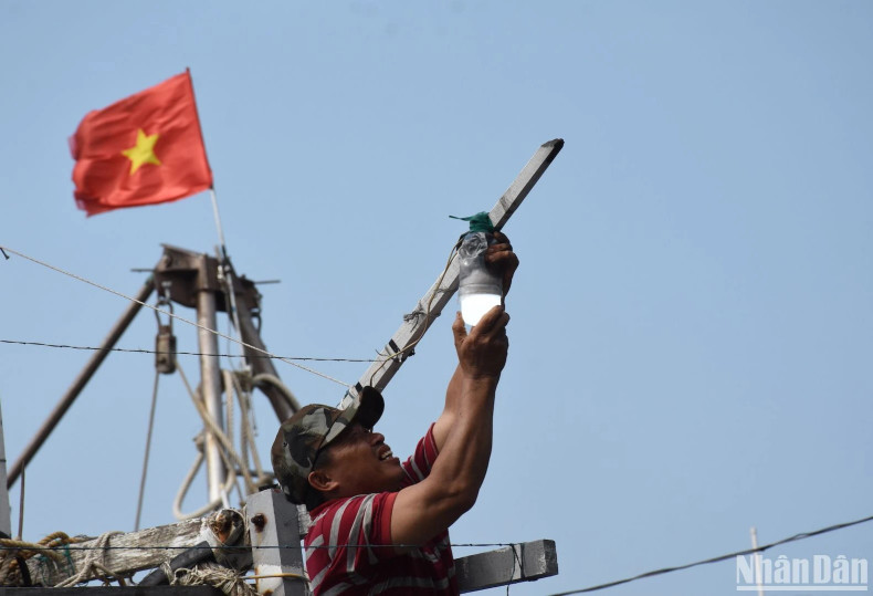 A fisherman is checking and reinstalling light bulbs on a fishing boat… A fisherman is checking and reinstalling light bulbs on a fishing boat…
