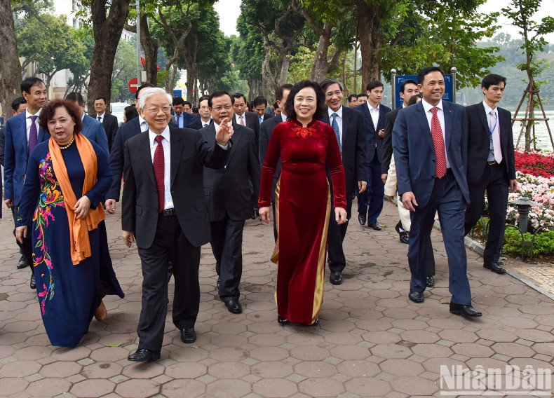 In the early spring atmosphere, Party General Secretary Nguyen Phu Trong and other delegates walk along the shore of Hoan Kiem Lake.