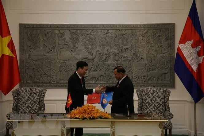 Politburo member Vo Van Thuong and the CPP's Vice President Say Chhum sign an agreement on delegation exchange between the CPV and the CPP for 2022-2024. (Photo: VNA)
