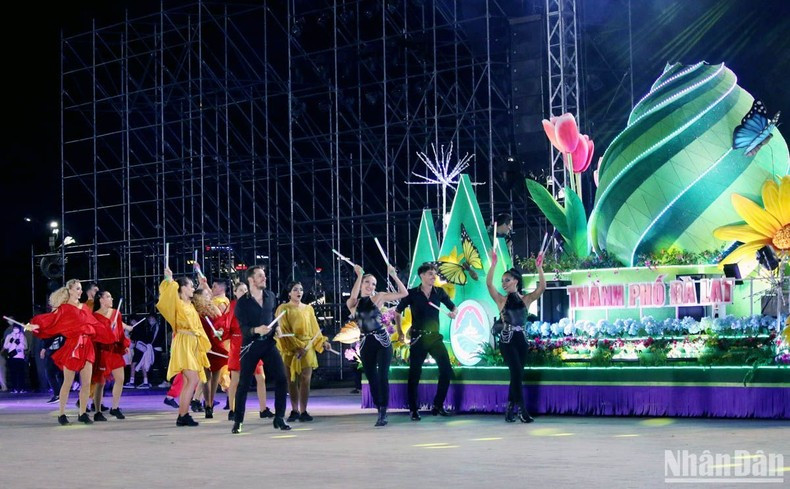 Artists perform beside vehicles showing the symbols of Da Lat City. (Photo: NDO)