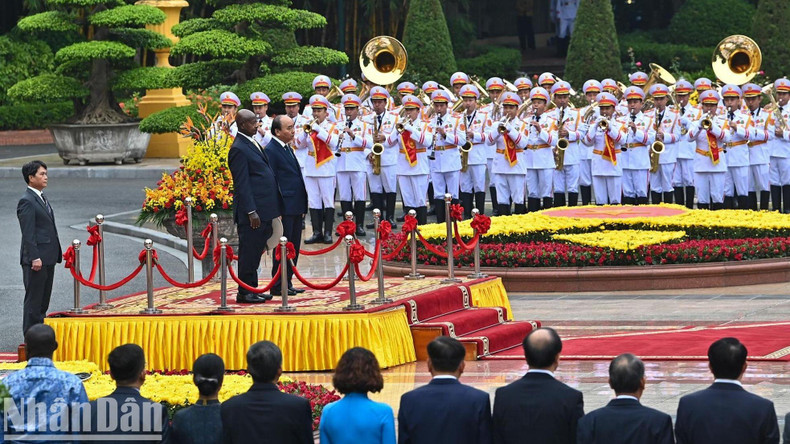 President Nguyen Xuan Phuc and his Ugandan counterpart Yoweri Kaguta Museveni stand on the podium listen to the playing of the two countries’ national anthems.