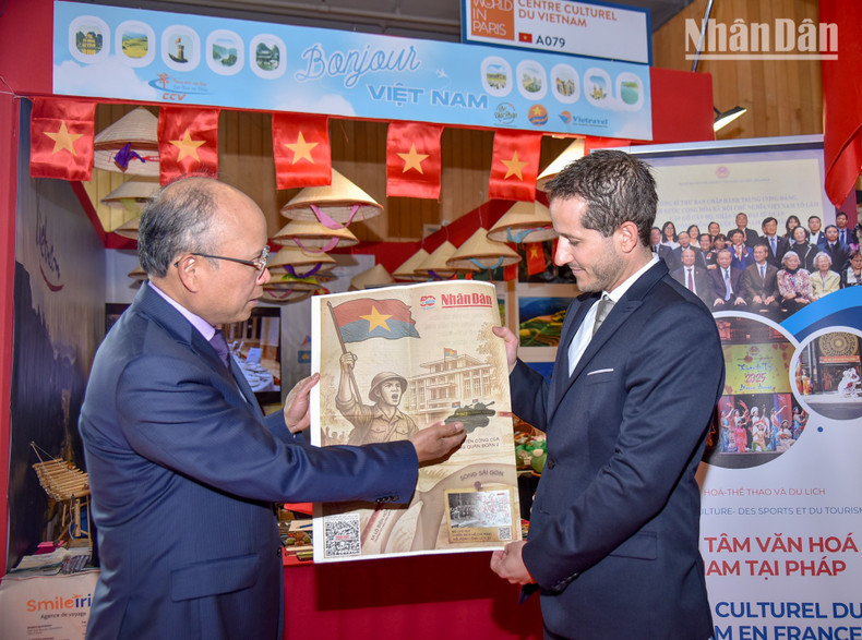 Vietnamese Ambassador to France Dinh Toan Thang introduces the special supplement to Steven Abajoli, Director of the 2025 Paris International Fair, as part of the commemoration of the 50th anniversary of national reunification.