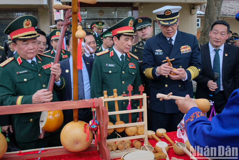 The two ministers admire local handicraft products.