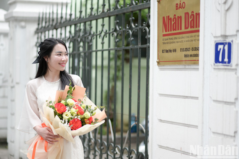The female staff gather at the office entrance to capture elegant moments in their Ao Dai.
