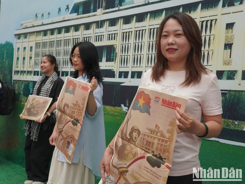Young visitors, carrying the special supplement in hand, take souvenir photos.