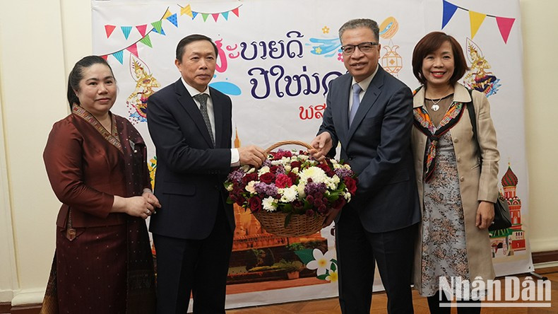 Ambassador Dang Minh Khoi presents flowers and extends his best wishes to Ambassador Siphandone Oybuabuddy. Ambassador Dang Minh Khoi presents flowers and extends his best wishes to Ambassador Siphandone Oybuabuddy.