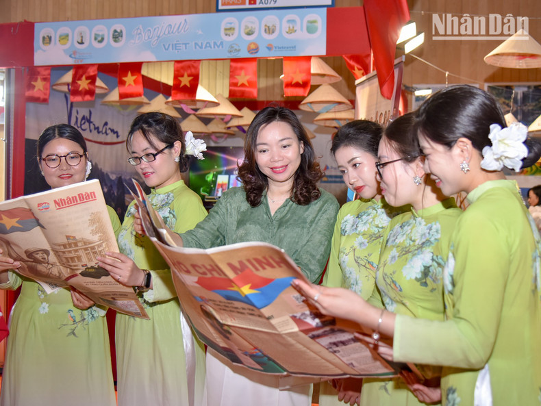 Minister Counsellor Pham Thi Kim Yen from the Vietnamese Embassy in France, along with Vietnamese students, view the special edition, which includes detailed information on the Ho Chi Minh Campaign and the iconic moment of the liberation army capturing the Independence Palace.
