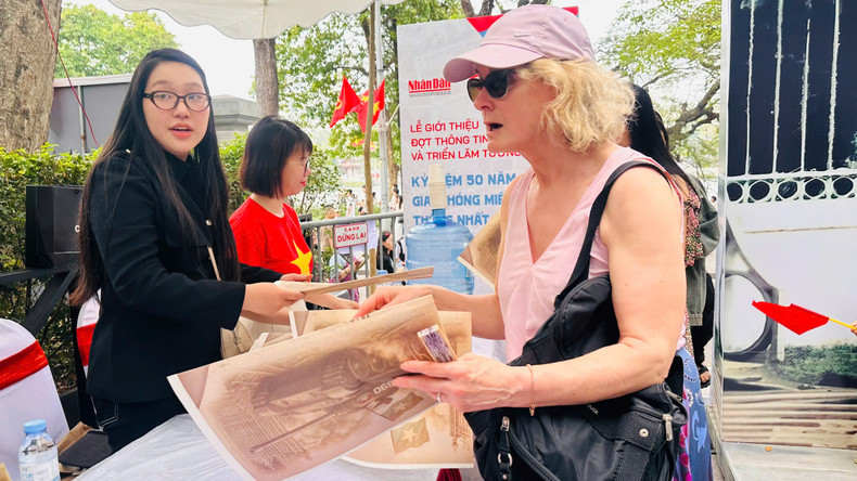 Lucia (from Ireland) receives Nhan Dan Newspaper's special supplement.