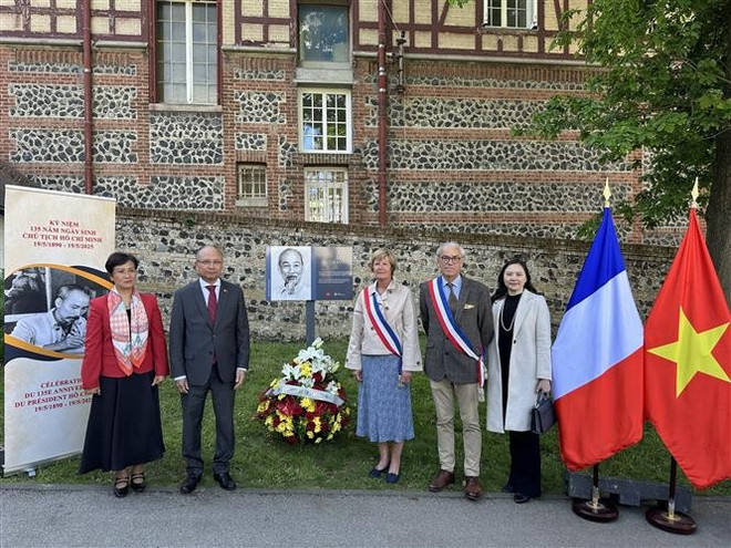 Leaders of the Vietnamese Embassy in France and representatives of Sainte-Adresse city pose for a photo beside the memorial plaque dedicated to President Ho Chi Minh. (Photo: VNA)