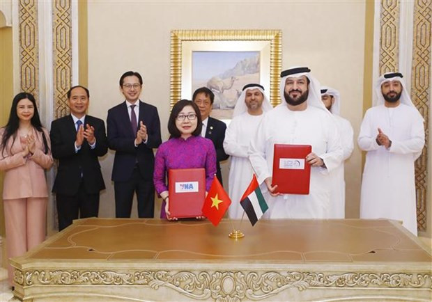 VNA Deputy Director General Doan Thi Tuyet Nhung and WAM Director-General Mohamed Jalal Al Rayssi sign a professional cooperation agreement between the two agencies. (Photo: VNA)