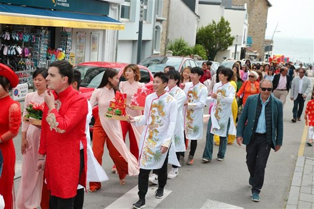 Vietnamese and international students in "ao dai", a traditional costume of Vietnam, reenact a traditional wedding of Vietnam at the festival. (Photo: VNA) Vietnamese and international students in "ao dai", a traditional costume of Vietnam, reenact a traditional wedding of Vietnam at the festival. (Photo: VNA)