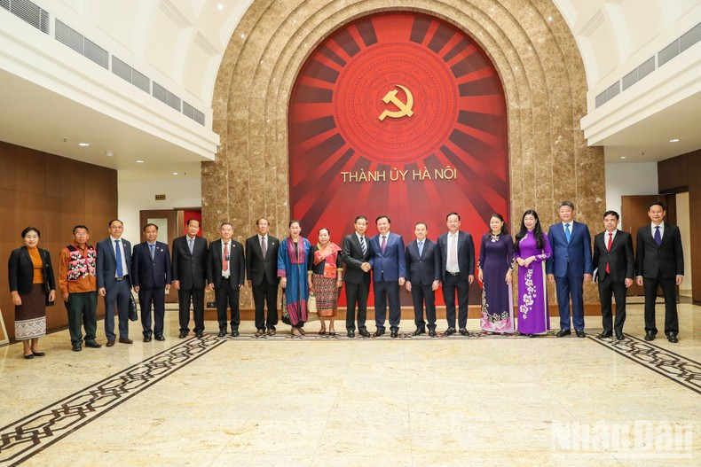 Secretary of Hanoi municipal Party Committee Dinh Tien Dung and President of the Central Committee of Lao Front for National Construction Sinlavong Khoutphaythoune, along with other delegates, pose for a photo.