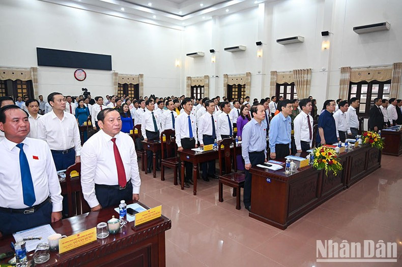 NA Chairman Vuong Dinh Hue and other delegatesperform the flag-saluting ceremony at the opening of the session.