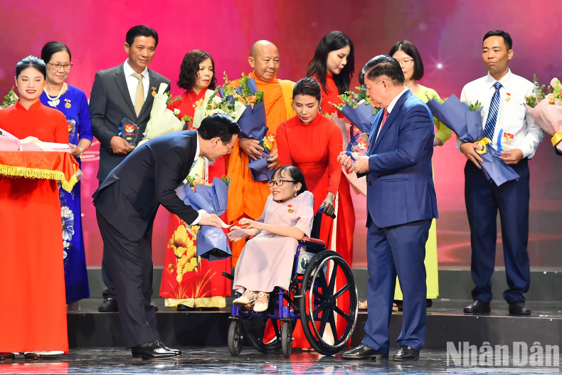 President Vo Van Thuong and Head of the PCC’s Communications and Education Nguyen Trong Nghia present flowers and symbols to outstanding examples at the programme.