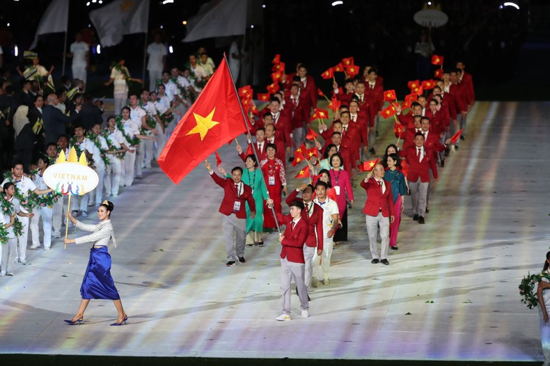 The Vietnamese sports delegation marches at the opening ceremony. Swimmer Nguyen Huy Hoang, who won eight SEA Games gold medals, holds the Vietnamese flag.