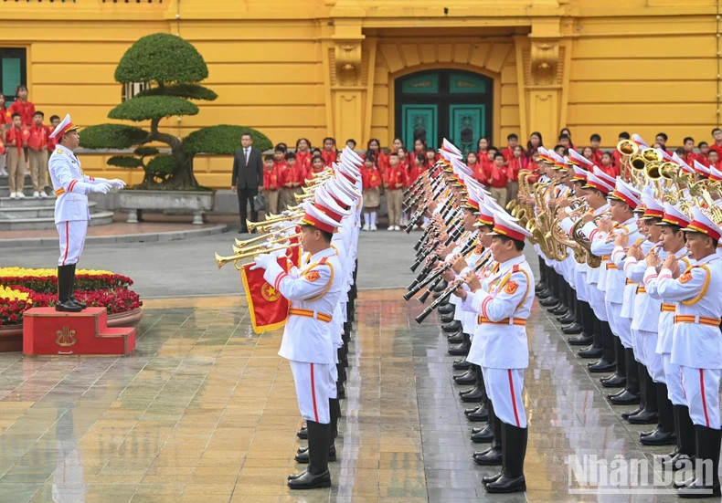 The military band perform the national anthems of the two countries.