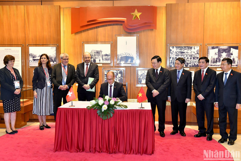 President of the National Council of Switzerland Martin Candinas writes on the golden guestbook at the Vietnam NA’s historical room, as a memento. President of the National Council of Switzerland Martin Candinas writes on the golden guestbook at the Vietnam NA’s historical room, as a memento.