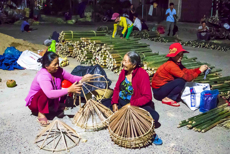Nguyen Thi Thanh goes straight to the market with her bunches of hats. The total of 35 conical hats are the result of more than a week of her and her children working together. Having made hats for years, she mainly sells to regular customers, and never worries about poor sales.