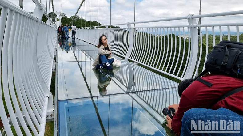 Visitors takes photos with Ngan Thong Glass Bridge.
