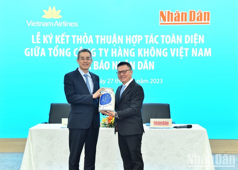 Nhan Dan Newspaper’s Editor-in-chief Le Quoc Minh presents the souvenir to Chairman of the Board of Management of Vietnam Airlines Dang Ngoc Hoa.