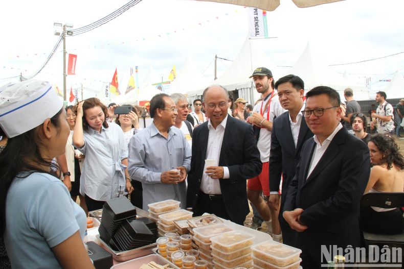 Editor-in-Chief Le Quoc Minh and Ambassador Dinh Toan Thang visit the booth of Laos.