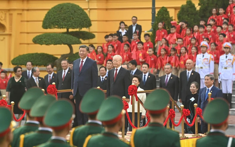 Party General Secretary Nguyen Phu Trong and Chinese Party General Secretary and President Xi Jinping perform the flag salute ceremony.