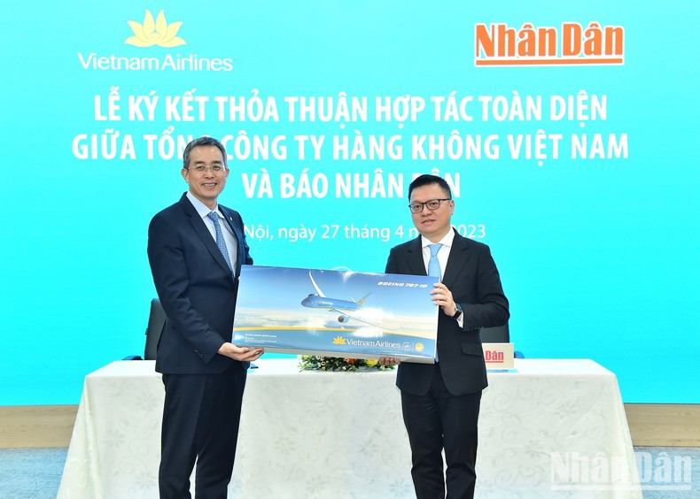 Chairman of the Board of Management of Vietnam Airlines Dang Ngoc Hoa presents a souvenir to Nhan Dan Newspaper’s Editor-in-chief Le Quoc Minh.