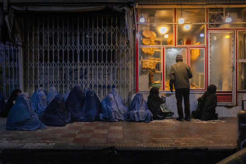 Women and children beg for bread outside a bakery in central Kabul, Afghanistan. (Source: World Press Photo)