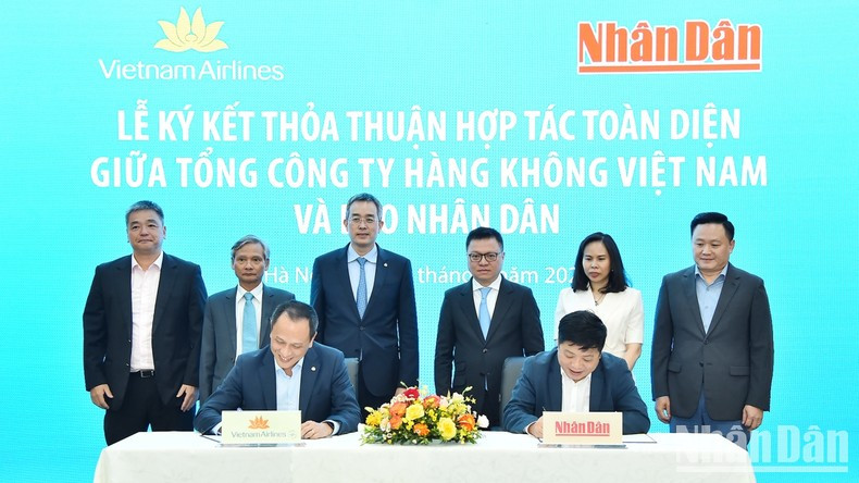 Leaders from Nhan Dan Newspaper and Vietnam Airlines witness the signing of the comprehensive cooperation agreement.