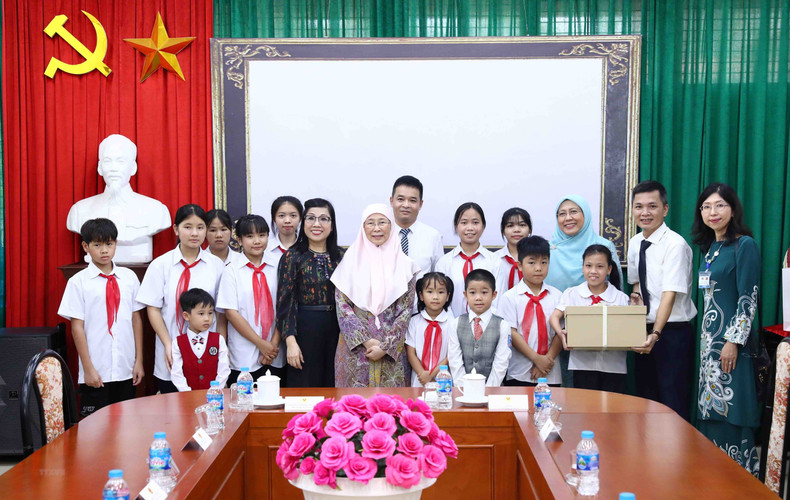 Vietnamese and Malaysian PMs’ spouses present gifts to the children at the village. (Photo: VNA) Vietnamese and Malaysian PMs’ spouses present gifts to the children at the village. (Photo: VNA)