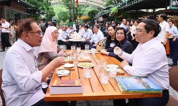Vietnamese Prime Minister Pham Minh Chinh, his visiting Malaysian counterpart Anwar Ibrahim and their spouses enjoyed coffee at the outdoor reading space on Hanoi's book street. (Photo: VNA)