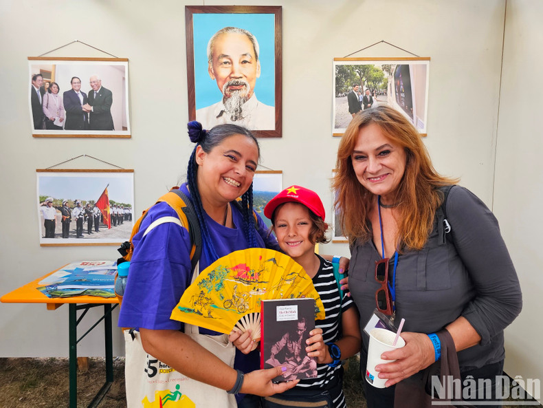 Ana Mesquita (left), her mother and her son expressed their happiness when taking photos under the portrait of President Ho Chi Minh and were presented with books about the great leader of Vietnam.