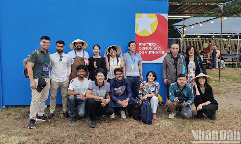 Portuguese and overseas Vietnamese volunteers help Nhan Dan Newspaper arrange the booth.