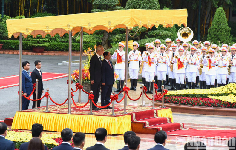 PM Pham Minh Chinh and his Singaporean counterpart Lee Hsien Loong perform the flag-raising ceremony of the two countries. PM Pham Minh Chinh and his Singaporean counterpart Lee Hsien Loong perform the flag-raising ceremony of the two countries.